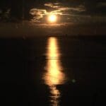Sunset over water with a pier.