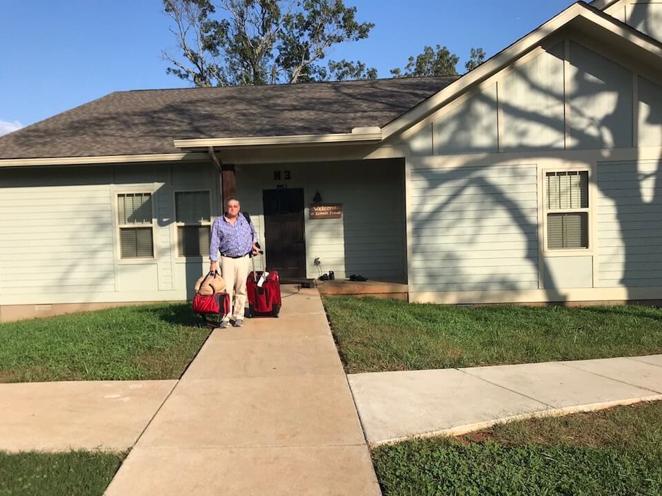 Man carrying bags outside house