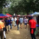 Crowd under tents at outdoor event.