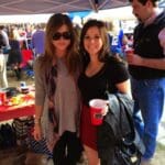 Two women and a man at a tailgate party.