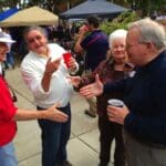 Group of people at a party, smiling and talking.