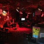 Red neon signs in a dimly lit bar.