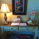 Wooden table with guitar and sign.