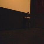 A man in a dark room holding something.