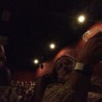 Two people in a dark movie theater.
