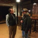Two men talking in a restaurant.