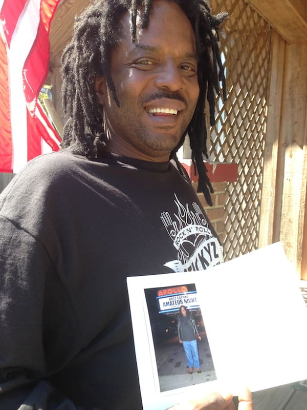 Man smiling while holding a photograph