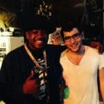 Two men smiling, one wearing a black shirt.