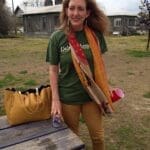 Woman in green shirt with a scarf and a beer.