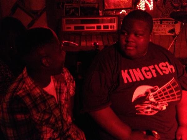 Friends chatting in a red-lit bar.