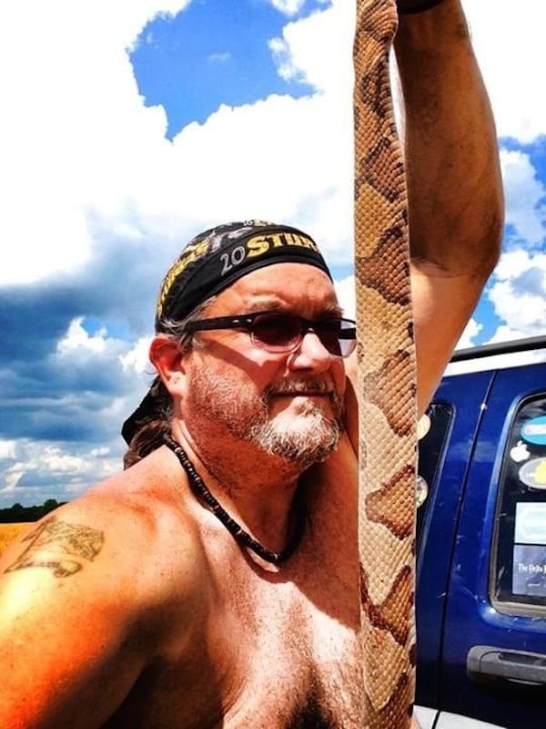 Person with snake near a truck
