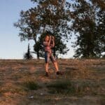 Woman taking a photo on a hill.