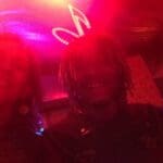 Two people pose in a red light club.