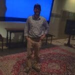 Man standing in a room with a rug.