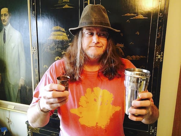 Long-haired man with hat and cups