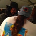 A man in a hat smiles at a woman.