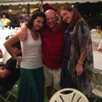 Three friends smiling at a party.