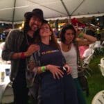 Three friends smiling at a party.