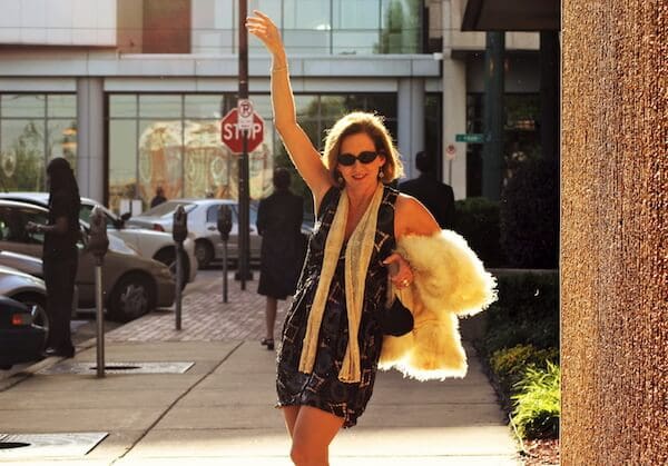 Woman waving on city street