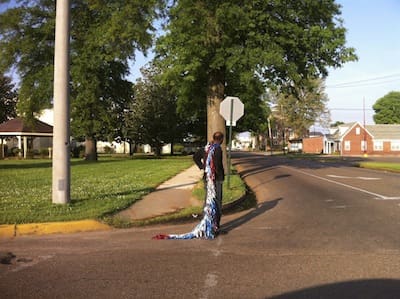 Individual in flowing attire near stop sign
