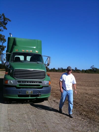 Person in field with green truck