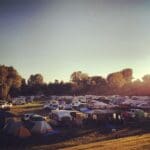 Campground with tents and RVs at sunset.