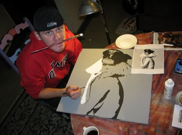 Man in red hoodie painting artwork