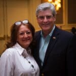 Man in suit with woman smiling.