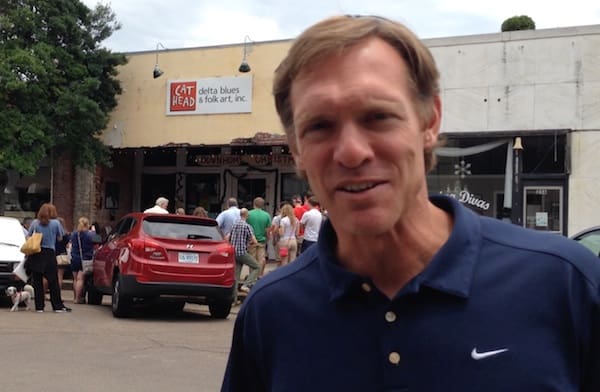 Man smiling in front of store