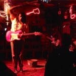 A man plays electric guitar on stage.