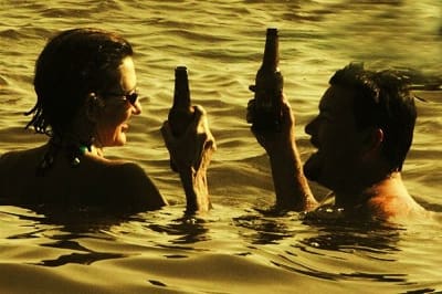 People toasting with bottles in water