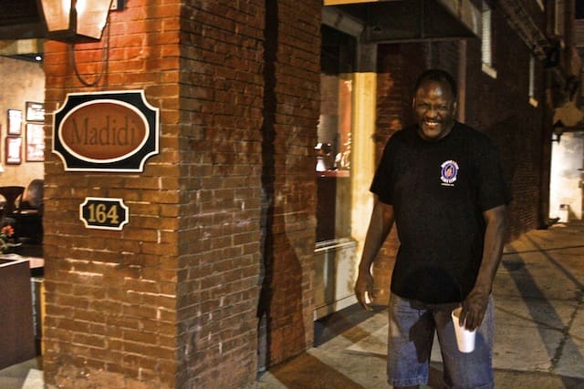 Smiling and lovable Madidi Custodian and all around lend-a-hander and GZBC mainstay Abraham Fox standing outside on final night of Madidi. Photo by Delta Bohemian