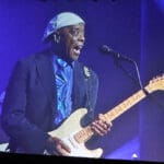 A man plays an electric guitar on stage.