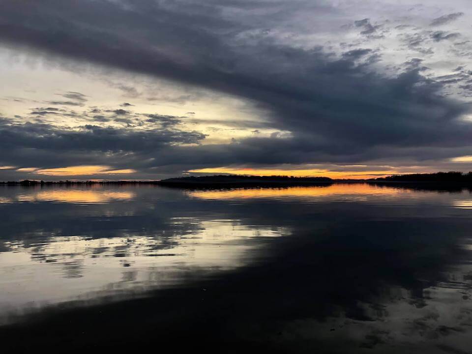 Tranquil evening lake scene with clouds