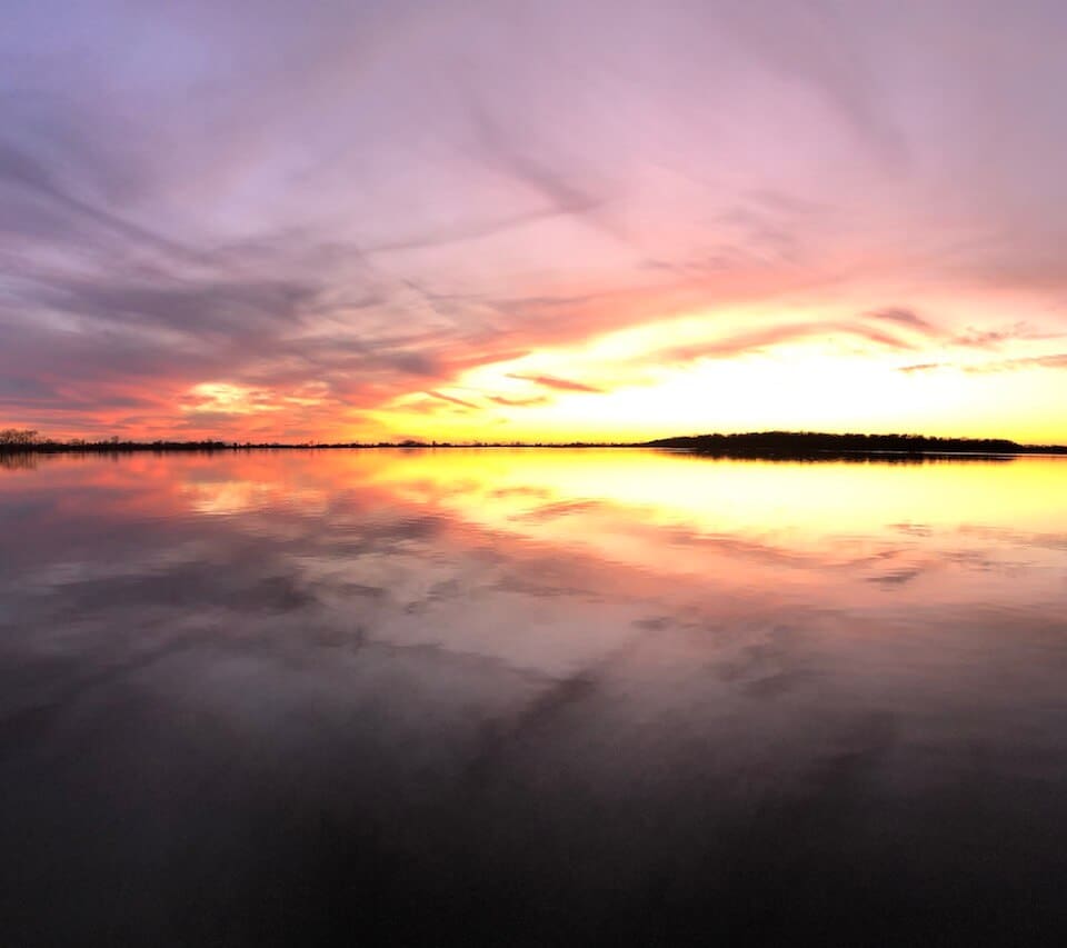 Colorful sunset over calm lake reflection