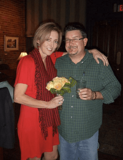 Smiling couple holding flowers indoors