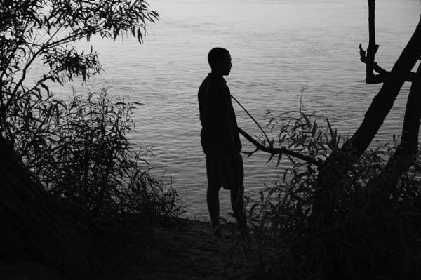 Man standing near water at dusk