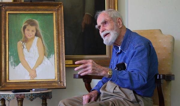 Artist Marshall Bouldin III next to a pastel portrait he painted of cousin Corinne Vance