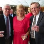 Three people smiling at a party.