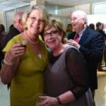 Two women smiling at a party.