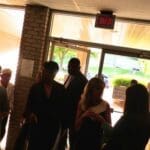 Group of people gathered near a doorway.