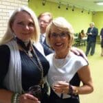 Two women smiling at a social event.