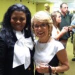 Two women smiling at a social event.