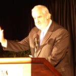 Man speaking at podium with microphone.