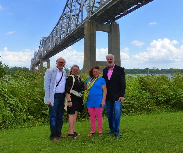 Group posing under large bridge