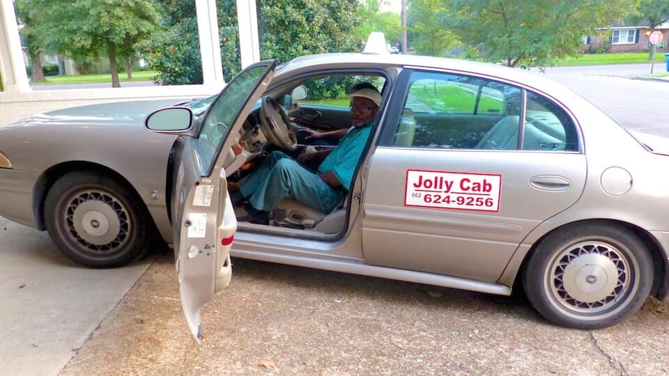 Man seated in Jolly Cab car