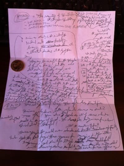 Cursive writing with a coin on paper