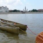 Two canoes docked in front of a city.