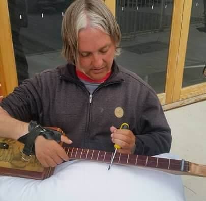 Person adjusting guitar-like instrument