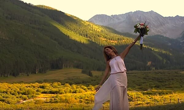 Woman posing with flowers in scenic valley